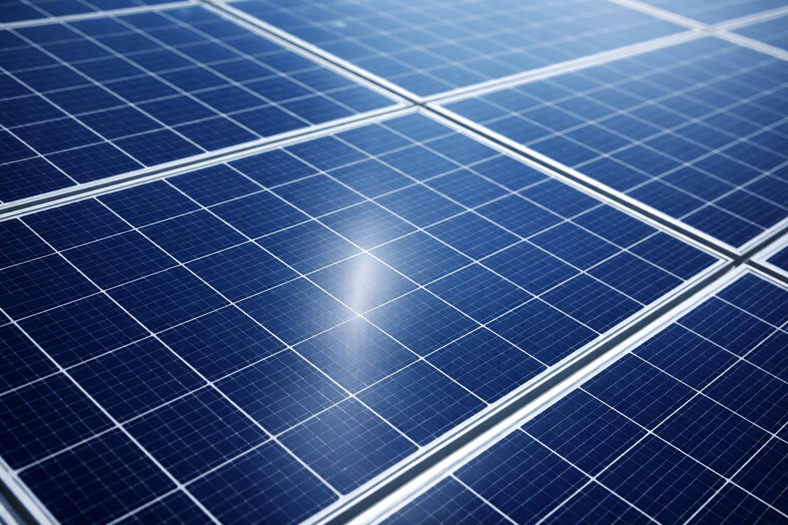 Close-up of blue solar panels with sunlight reflection